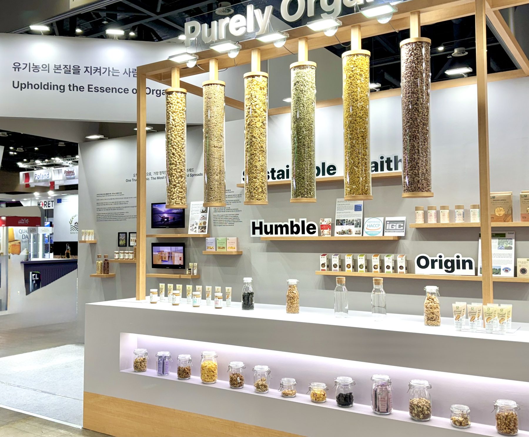 YOUGAONE brand exhibition at Seoul Food 2025 — the 'Purely Organic, Perfectly Premium' display wall with columns of organic nuts and grains