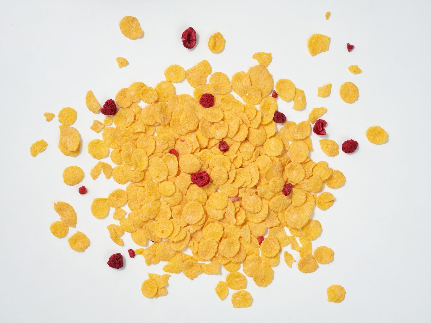 Organic cornflakes and red berries scattered