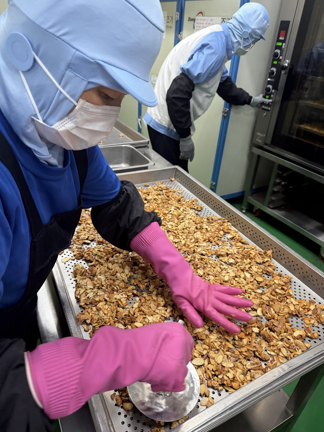 Glazed nut clusters being finished by hand on the oven line